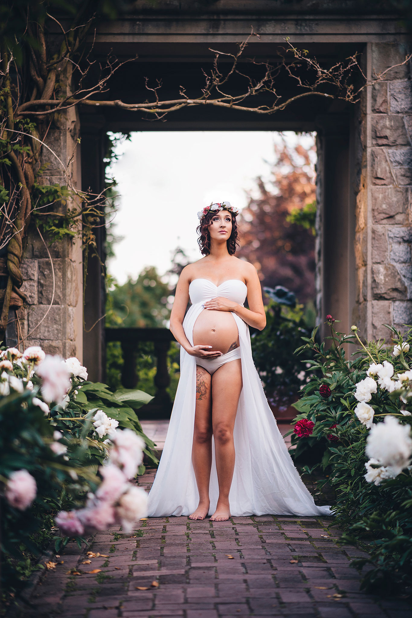 Maternity photography with flowing white maternity gown and flower crown at Hatley Castle near Victoria.