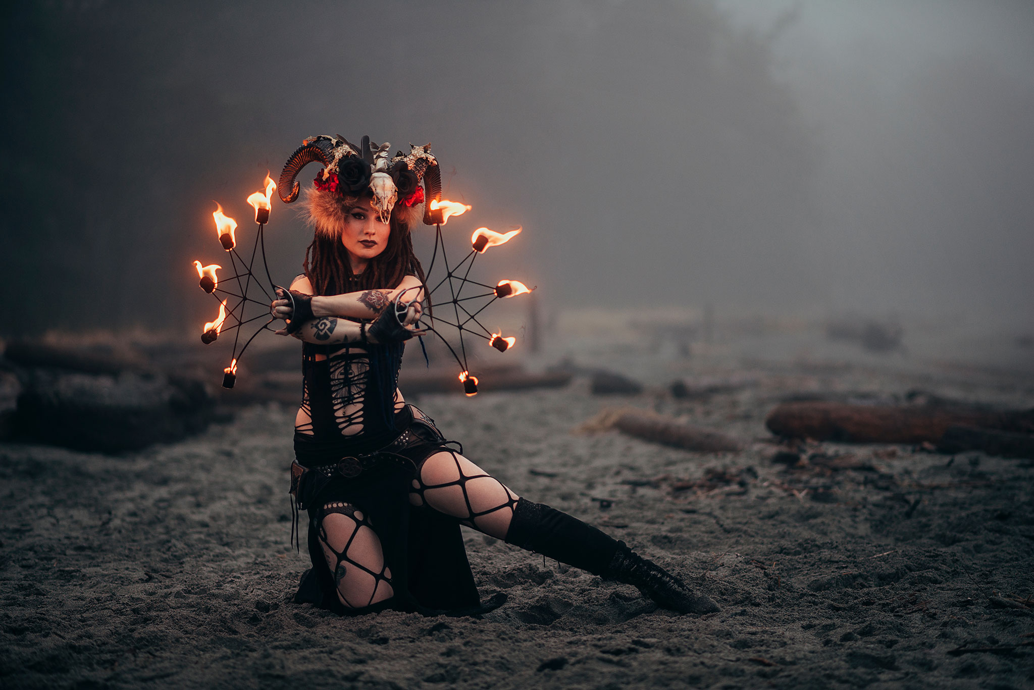 Alternative, tribal, gothic fire dancer on a foggy west coast beach in Comox.